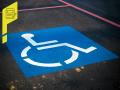 Der weiße Rollstuhlfahrer auf blauem Grund markiert einen Parkplatz. 